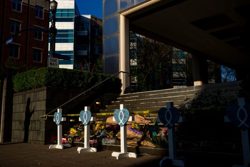 LOUISVILLE, KY - APRIL 12: A resident's shadow is cast on the wall next to a memorial outside of the Old National Bank following this week's mass shooting on April 12, 2023 in Louisville, Kentucky. On the morning of April 10, a gunman opened fire inside the Old National Bank building killing four people and injuring eight others. A fifth victim later died in the hospital. (Photo by Michael Swensen/Getty Images)