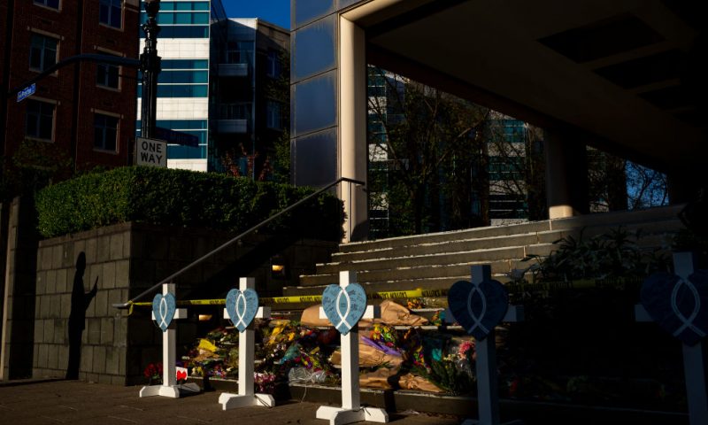 LOUISVILLE, KY - APRIL 12: A resident's shadow is cast on the wall next to a memorial outside of the Old National Bank following this week's mass shooting on April 12, 2023 in Louisville, Kentucky. On the morning of April 10, a gunman opened fire inside the Old National Bank building killing four people and injuring eight others. A fifth victim later died in the hospital. (Photo by Michael Swensen/Getty Images)