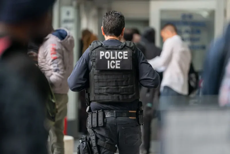 NEW YORK, NEW YORK - JUNE 6: An ICE agent monitors hundreds of asylum seekers being processed upon entering the Jacob K. Javits Federal Building on June 6, 2023 in New York City. New York City has provided sanctuary to over 46,000 asylum seekers since 2013, when the city passed a law prohibiting city agencies from cooperating with federal immigration enforcement agencies unless there is a warrant for the person's arrest.(Photo by David Dee Delgado/Getty Images)