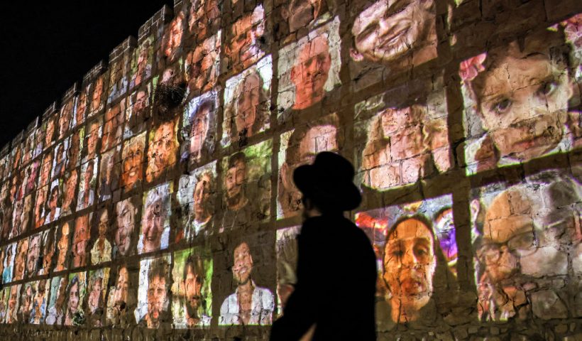 TOPSHOT - An Ultra-Orthodox Jewish man walks outside the walls of the old city of Jerusalem, on which are projected pictures of the hostages abducted by Palestinian militants on the October 7 attack and currently held in the Gaza Strip, on November 6, 2023, amid the ongoing battles between Israel and the militant group Hamas. (Photo by AHMAD GHARABLI / AFP) (Photo by AHMAD GHARABLI/AFP via Getty Images)