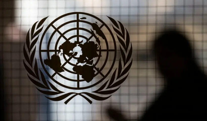 A person walks past the UN logo at UN headquarters on February 8 , 2024, in New York. (Photo by ANGELA WEISS / AFP) (Photo by ANGELA WEISS/AFP via Getty Images)