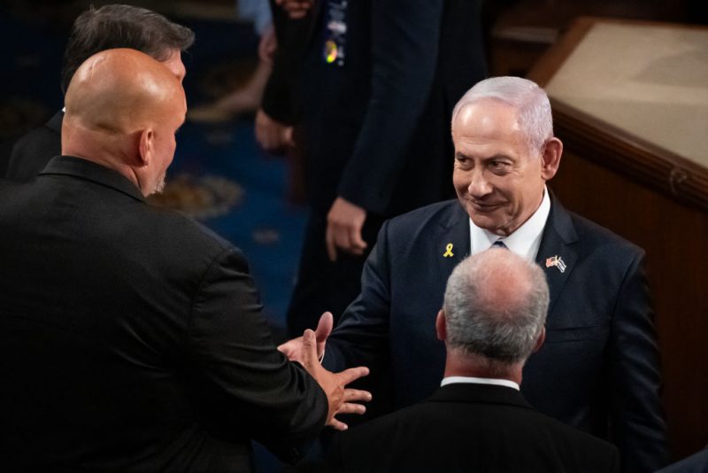 Israeli Prime Minister Benjamin Netanyahu (right) shakes hands with staunchly pro-Israel Sen, John Fetterman (D-PA) after delivering a controversial address to a joint session of Congress in Washington, DC, July 24, 2024. Traditionally presiding over joint sessions, Vice President Kamala Harris and Senate Democratic leaders declined to serve in that role for Netanyahu's speech, and many members of Congress boycotted the session. Millions of Americans object to the nature of Israel's response to the killing of 1200 of its citizens by Hamas on October 7, 2023. Israel's retaliation has killed more than 38,000 Palestinians, injured more than 88,000, and displaced roughly 1.9 million, according to the United Nations. (Photo by Allison Bailey / Middle East Images / Middle East Images via AFP) (Photo by ALLISON BAILEY/Middle East Images/AFP via Getty Images)