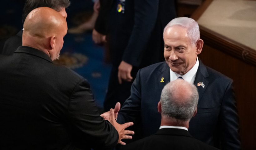 Israeli Prime Minister Benjamin Netanyahu (right) shakes hands with staunchly pro-Israel Sen, John Fetterman (D-PA) after delivering a controversial address to a joint session of Congress in Washington, DC, July 24, 2024. Traditionally presiding over joint sessions, Vice President Kamala Harris and Senate Democratic leaders declined to serve in that role for Netanyahu's speech, and many members of Congress boycotted the session. Millions of Americans object to the nature of Israel's response to the killing of 1200 of its citizens by Hamas on October 7, 2023. Israel's retaliation has killed more than 38,000 Palestinians, injured more than 88,000, and displaced roughly 1.9 million, according to the United Nations. (Photo by Allison Bailey / Middle East Images / Middle East Images via AFP) (Photo by ALLISON BAILEY/Middle East Images/AFP via Getty Images)