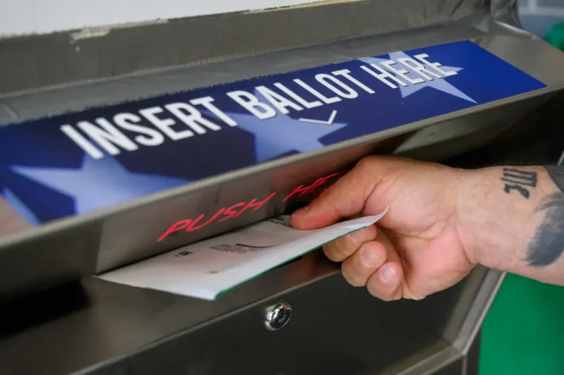 A voter uses a ballot drop box at the Bucks County Administration building voting on demand and ballot drop center in Doylestown, Pennsylvania, on October 31, 2024. (Photo by Ed JONES / AFP) (Photo by ED JONES/AFP via Getty Images)