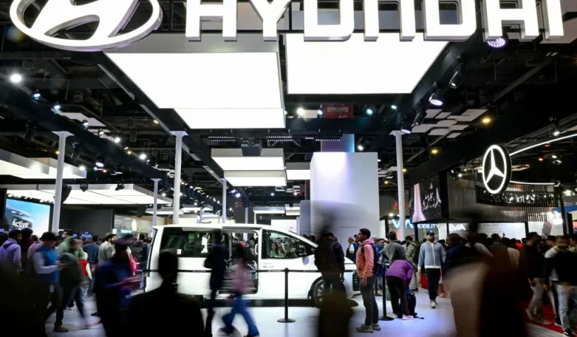 People walk past a Hyundai exhibition booth at the Bharat Mobility Global Expo 2025, in New Delhi on January 21, 2025. (Photo by Money SHARMA / AFP) (Photo by MONEY SHARMA/AFP via Getty Images)