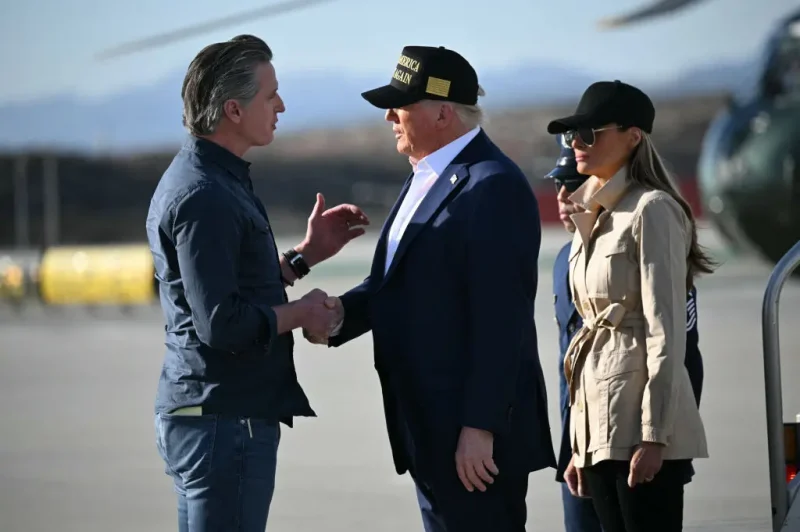 TOPSHOT - US President Donald Trump followed by First Lady Melania Trump, shakes hands with California Governor Gavin Newsom upon arrival at Los Angeles International Airport in Los Angeles, California, on January 24, 2025, to visit the region devastated by the Palisades and Eaton fires. (Photo by Mandel NGAN / AFP) (Photo by MANDEL NGAN/AFP via Getty Images)