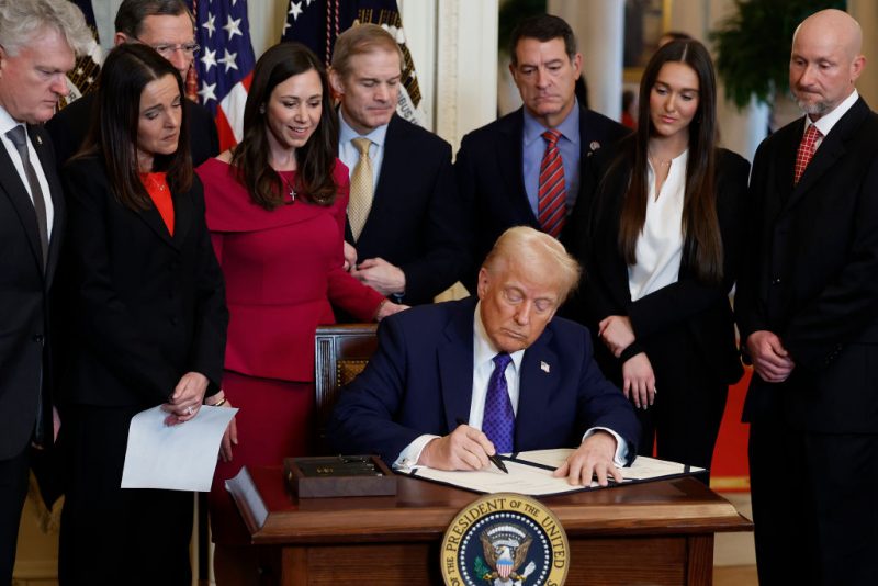 WASHINGTON, DC - JANUARY 29: Surrounded by members of Congress and the family of Laken Riley, U.S. President Donald Trump signs the Laken Riley Act, the first piece of legislation passed during his second term in office, in the East Room of the White House on January 29, 2025 in Washington, DC. Jason Riley and Allyson Philips, the parents of 22-year-old Laken Riley, a University of Georgia nursing student who was murdered in 2024 by an undocumented immigrant, attended the signing ceremony. Among other measures, the law directs law enforcement authorities to detain and deport immigrants who are accused but not yet convicted of specific crimes, if they are in the country illegally. (Photo by Chip Somodevilla/Getty Images)