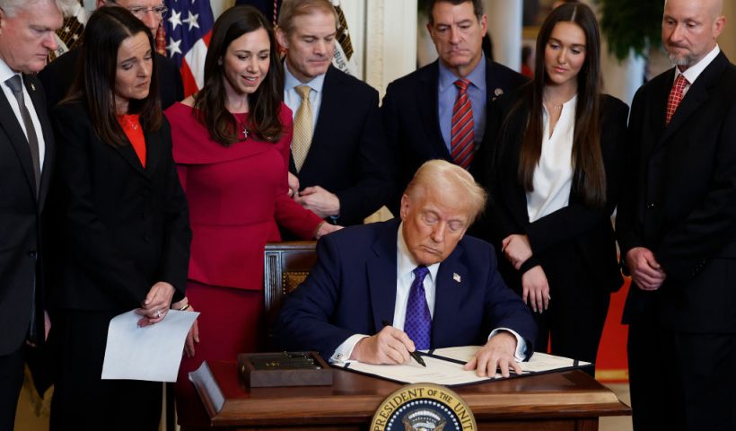 WASHINGTON, DC - JANUARY 29: Surrounded by members of Congress and the family of Laken Riley, U.S. President Donald Trump signs the Laken Riley Act, the first piece of legislation passed during his second term in office, in the East Room of the White House on January 29, 2025 in Washington, DC. Jason Riley and Allyson Philips, the parents of 22-year-old Laken Riley, a University of Georgia nursing student who was murdered in 2024 by an undocumented immigrant, attended the signing ceremony. Among other measures, the law directs law enforcement authorities to detain and deport immigrants who are accused but not yet convicted of specific crimes, if they are in the country illegally. (Photo by Chip Somodevilla/Getty Images)