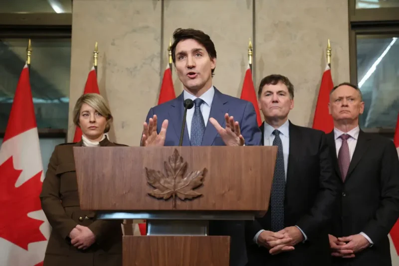 Canada's Prime Minister Justin Trudeau speaks during a news conference about the US tariffs against Canada on March 4, 2025 on Parliament Hill in Ottawa, as (L-R) Foreign Minister Melanie Joly, Minister of Finance and Intergovernmental Affairs Dominic Leblanc and Minister of Public Safety David McGuinty look on. Trudeau said that President Donald Trump imposed tariffs on Canada to destroy the country's economy to make it easier for the United States to annex its northern neighbor. The extraordinary warning about Trump's threat to Canadian sovereignty came as the US president delivered on his vow to impose 25 percent tariffs on all Canadian goods. (Photo by Dave Chan / AFP) (Photo by DAVE CHAN/AFP via Getty Images)
