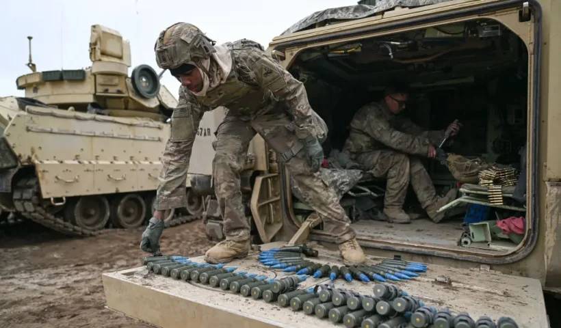 DRAWSKO POMORSKIE, POLAND - MARCH 13: A soldier of the US Army 3rd Brigade, 1st Armored Division prepares 25mm shells on the back of a Bradley Fighting Vehicle ahead of a live fire exercise at the Drawsko Pomorskie training area on March 13, 2025 in Drawsko Pomorskie, Poland. Poland has historically been one of America's closest European allies, currently hosting approximately 10,000 members of the US Armed Forces, who play a significant role in reinforcing security along NATO's eastern flank. Recently, however, the United States' ongoing military presence in Europe has been cast into doubt, as US President Donald Trump pressures NATO member states to increase their defence spending, and to decrease their reliance on America for its military funding and resources. (Photo by Omar Marques/Getty Images)