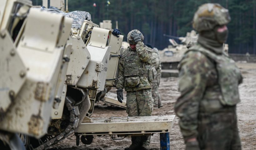 DRAWSKO POMORSKIE, POLAND - MARCH 13: Soldiers of the US Army 3rd Brigade, 1st Armored Division speak next to a Bradley Fighting Vehicle ahead of a live fire exercise at the Drawsko Pomorskie training area on March 13, 2025 in Drawsko Pomorskie, Poland. Poland has historically been one of America's closest European allies, currently hosting approximately 10,000 members of the US Armed Forces, who play a significant role in reinforcing security along NATO's eastern flank. Recently, however, the United States' ongoing military presence in Europe has been cast into doubt, as US President Donald Trump pressures NATO member states to increase their defence spending, and to decrease their reliance on America for its military funding and resources. (Photo by Omar Marques/Getty Images)