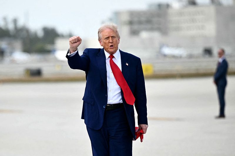 TOPSHOT - US President Donald Trump pumps his fist upon arrival at Miami International Airport on April 3, 2025. Trump is travelling to the Trump National Doral Golf Club before going to his Mar-a-Lago Resort. (Photo by Mandel NGAN / AFP) (Photo by MANDEL NGAN/AFP via Getty Images)