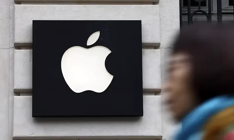 A woman walks past an Apple logo at an Apple store in Paris, France, April 23, 2025. REUTERS/Abdul Saboor