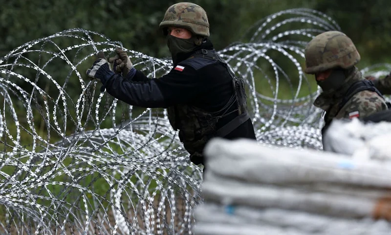 Polish soldiers construct a barbed wire fence on the border with Belarus in Zubrzyca Wielka near Bialystok, eastern Poland on August 26, 2021. - The Polish Ministry of Defence has announced the building of a one hundred kilometer long, two and a half meter high fence along it's border with Belarus after a significant increase in refugee crossings. (Photo by Jaap Arriens / AFP) (Photo by JAAP ARRIENS/AFP via Getty Images)