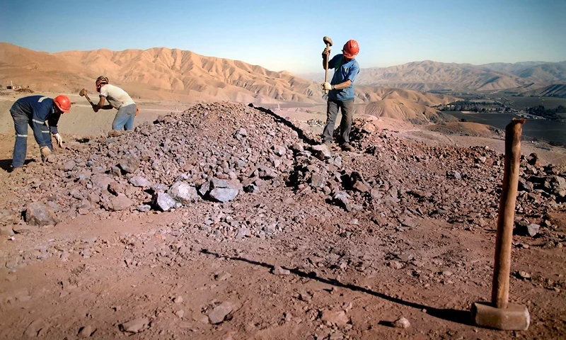 TOPSHOT - TO GO WITH AFP STORY by Moises Avila Roldan Miners Rigoberto Oliveros, Luis Moya and Emilio Tapia crush rocks before putting them into filters for the extraction of the mineral, at the San Javier mine in Copiapo, in the Atacama desert 800 km north of Santiago, on August 27, 2010. AFP PHOTO/ARIEL MARINKOVIC (Photo by ARIEL MARINKOVIC / AFP) (Photo by ARIEL MARINKOVIC/AFP via Getty Images)