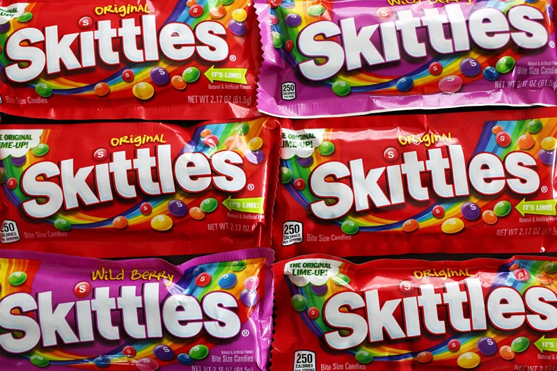 LOS ANGELES, CALIFORNIA - MAY 30: In this photo illustration, packages of Skittles sit on a table on May 30, 2023 in Los Angeles, California. California lawmakers are considering a law banning five chemical food additives over health concerns including the coloring agent used in Skittles candy. (Photo Illustration by Mario Tama/Getty Images)