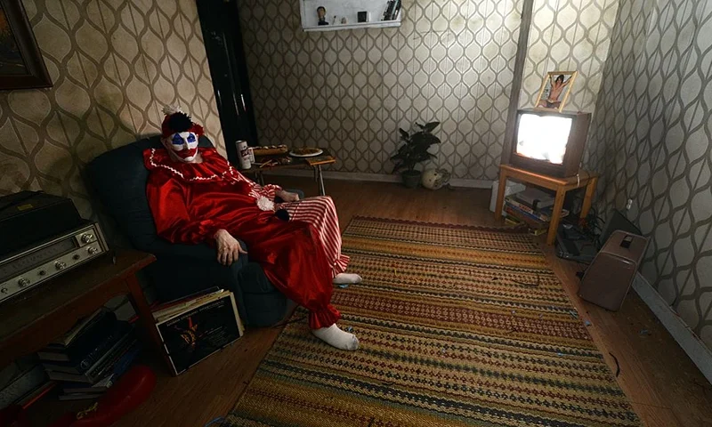 An actor portrays serial killer John Wayne Gacy at Killers: A Nightmare Haunted House, at Clemente Soto Vélez Cultural Center on October 5, 2012. Visitors can see a exhibit of drawings and other artifacts once belonging to real-life monsters such as John Wayne Gacy and Charles Manson, donated by an anonymous collector. Each room of the house depicts a scene based on a notorious serial killer, with performers acting as murderers, victims, or both. Killers will run September 28 through November 3, 2012 on Manhattan’s Lower East Side. AFP PHOTO / TIMOTHY A. CLARY (Photo credit should read TIMOTHY A. CLARY/AFP/GettyImages)