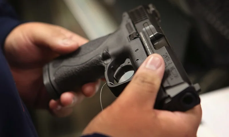 TINLEY PARK, IL - DECEMBER 17: A customer shops for a pistol at Freddie Bear Sports sporting goods store on December 17, 2012 in Tinley Park, Illinois. Americans purchased a record number of guns in 2012 and gun makers have reported a record high in demand. Firearm sales have surged recently as speculation of stricter gun laws and a re-instatement of the assault weapons ban following the mass school shooting in Connecticut . (Photo by Scott Olson/Getty Images)