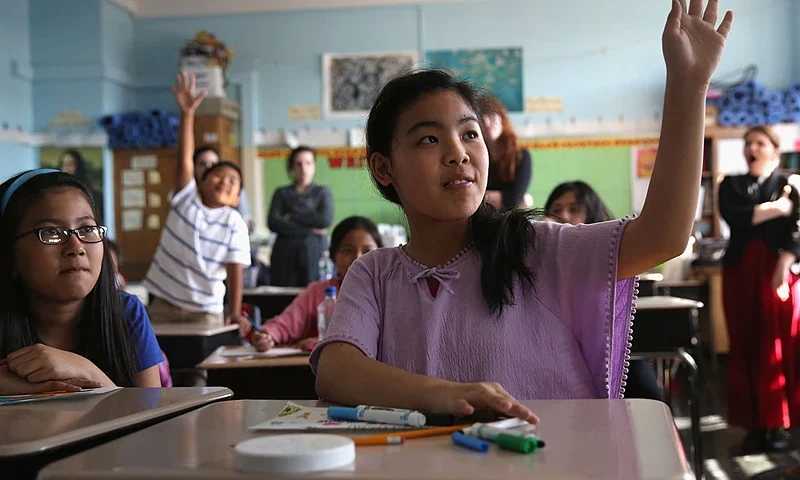 NEW YORK, NY - APRIL 25: Tibetan immigrant children raise their hands during an after-school program for asylum immigrants run by the International Rescue Committee (IRC), on April 25, 2013 in the Queens borough of New York City. The after-school program held at P.S. 199 consists of homework help and visual art instruction for Tibetan children in grades 2 through 4. The IRC is a non-profit humanitarian aid organization that aids refugees and survivors of international conflict. They assist new arrivals, many of whom come from refugee camps and war zones, to adjust to American society after being granted refugee status and invited by the U.S. government to live in the United States. The IRC also assists refugees through the immigration and naturalization process to become U.S. citizens. (Photo by John Moore/Getty Images)