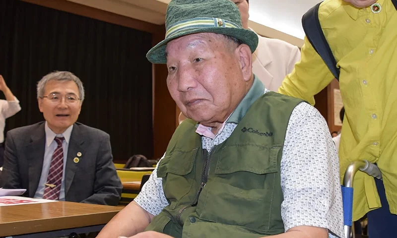 This photo taken on September 29, 2024 shows Iwao Hakamada (C) entering the venue during a judgement report session held by supporters in the city of Shizuoka, Shizuoka prefecture, two days after he was acquitted, more than half a century after his murder conviction, when a Japanese court ruled that evidence had been fabricated. Hakamada, now 88 years old, spent 46 years on death row after being convicted in 1968 of robbing and killing his boss, the man's wife and their two teenage children. (Photo by JIJI Press / AFP) / Japan OUT (Photo by STR/JIJI Press/AFP via Getty Images)