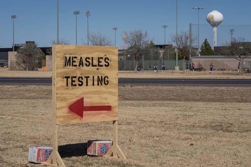 SEMINOLE, TEXAS - FEBRUARY 27: Signs point the way to measles testing in the parking lot of the Seminole Hospital District across from Wigwam Stadium on February 27, 2025 in Seminole, Texas. Eighty cases of measles have been reported in Gaines county with one death reported. (Photo by Jan Sonnenmair/Getty Images)