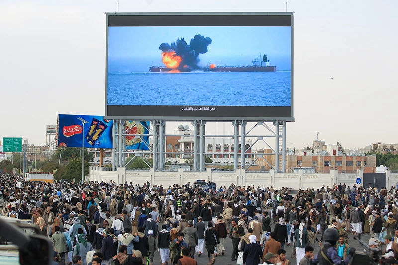 TOPSHOT - Images of a fireball exploding on a cargo ship are shown on a giant screen during a protest called for by Yemen's rebel Huthi movement in Sanaa on March 17, 2025. Huge crowds joined protests in rebel-controlled Yemen on March 17 after deadly US strikes killed dozens and sparked fears of a new cycle of violence in the conflict-torn country. (Photo by Mohammed HUWAIS / AFP) (Photo by MOHAMMED HUWAIS/AFP via Getty Images)