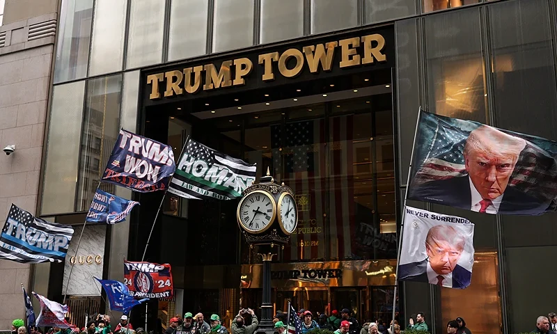 Supporters of US President Donald Trump gather outside Trump Tower holding flags during the annual St. Patrick's Day Parade in New York City on March 17, 2025. (Photo by CHARLY TRIBALLEAU / AFP) (Photo by CHARLY TRIBALLEAU/AFP via Getty Images)