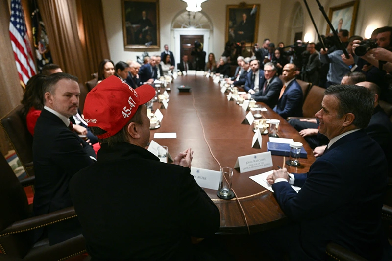 Elon Musk, wearing a red hat, speaks as US President Donald Trump hosts a cabinet meeting in the Cabinet Room of the White House on March 24, 2025, in Washington, DC. (Photo by Brendan SMIALOWSKI / AFP) (Photo by BRENDAN SMIALOWSKI/AFP via Getty Images)