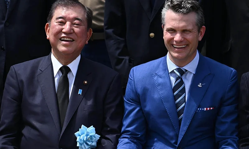 Japan's Prime Minister Shigeru Ishiba (L) sits with US Secretary of Defence Pete Hegseth (R) as they pose for a commemorative photograph during a joint US-Japan memorial service for the 80th anniversary of the Battle of Iwo Jima near the end of World War II, in the village of Ogasawara on Iwo Jima island, some 1,250 kilometres (780 miles) from Tokyo on March 29, 2025. Japan and the US called on March 29 for a strengthening of their alliance as Japan's Prime Minister Shigeru Ishiba and new US Defence Secretary Pete Hegseth attended a ceremony marking the 80th anniversary of the Battle of Iwo Jima. (Photo by JAPAN POOL / JIJI Press / AFP) / Japan OUT (Photo by JAPAN POOL/JIJI Press/AFP via Getty Images)