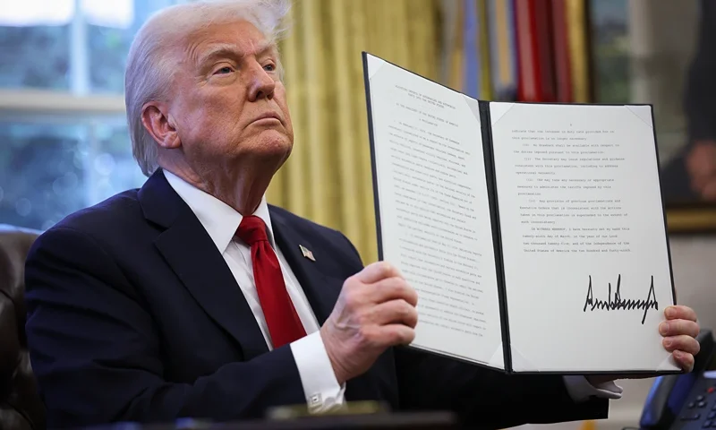 WASHINGTON, DC - MARCH 26: U.S. President Donald Trump displays a signed an executive order in the Oval Office of the White House on March 26, 2025 in Washington, DC. President Trump announced 25% tariffs on all foreign-made cars. (Photo by Win McNamee/Getty Images)