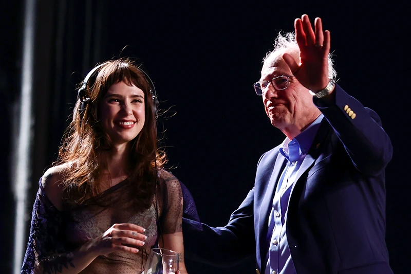 INDIO, CALIFORNIA - APRIL 12: (FOR EDITORIAL USE ONLY) (L-R) Clairo and Bernie Sanders speak onstage at Outdoor Theatre during the 2025 Coachella Valley Music and Arts Festival at Empire Polo Club on April 12, 2025 in Indio, California. (Photo by Emma McIntyre/Getty Images for Coachella)
