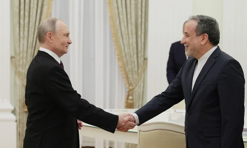TOPSHOT - In this pool photograph distributed by the Russian state agency Sputnik, Russia's President Vladimir Putin shakes hands with Iran's Foreign Minister Abbas Araghchi during a meeting at the Kremlin in Moscow on April 17, 2025. (Photo by Gavriil Grigorov / POOL / AFP) (Photo by GAVRIIL GRIGOROV/POOL/AFP via Getty Images)