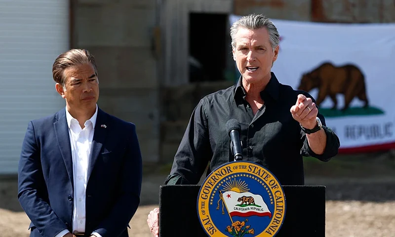 CERES, CALIFORNIA - APRIL 16: California Governor Gavin Newsom (R) speaks as California Attorney general Rob Bonta looks on during a news conference at Gemperle Orchard on April 16, 2025 in Ceres, California. Governor Gavin Newsom and California Attorney General Rob Bonta have filed a lawsuit in federal court challenging the Trump administration's use of emergency powers to enact sweeping tariffs that hurt states, consumers, and businesses. The tariffs have disrupted supply chains, increased costs for the state and Californians, and inflicted billions in damages on California’s economy, the fifth largest in the world. (Photo by Justin Sullivan/Getty Images)
