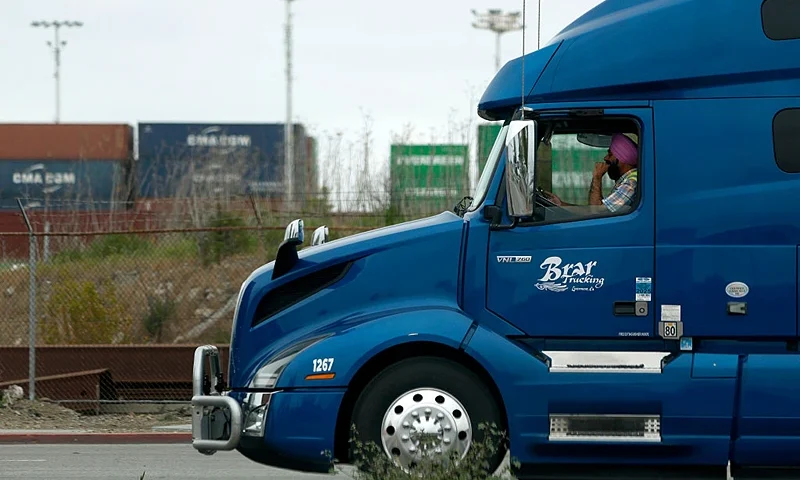 OAKLAND, CALIFORNIA - APRIL 18: A truck driver sits in line as he waits to enter a shipping berth at the Port of Oakland on April 18, 2025 in Oakland, California. The commercial transportation industry is bracing for a sudden drop in work as fallout from U.S. President Donald Trump's sweeping tariffs continues. American importers are being notified of a surge in canceled sailings by freight ships out of China after the Trump administration announced new fees on Chinese ships. (Photo by Justin Sullivan/Getty Images)