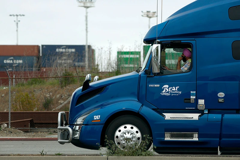 OAKLAND, CALIFORNIA - APRIL 18: A truck driver sits in line as he waits to enter a shipping berth at the Port of Oakland on April 18, 2025 in Oakland, California. The commercial transportation industry is bracing for a sudden drop in work as fallout from U.S. President Donald Trump's sweeping tariffs continues. American importers are being notified of a surge in canceled sailings by freight ships out of China after the Trump administration announced new fees on Chinese ships. (Photo by Justin Sullivan/Getty Images)