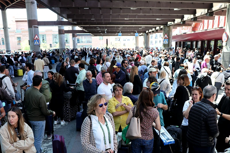 People wait outside the Atocha train station in Madrid after its closure as a massive power outage hits Spain on April 28, 2025. Power went out across all of Spain and Portugal today, cutting cellphone and internet networks, halting trains and trapping people in elevators, officials said. The operator, Red Electrica, said it would likely take six to 10 hours to restore power in the country and urged people not to speculate as to the cause of the outage. (Photo by Thomas COEX / AFP) (Photo by THOMAS COEX/AFP via Getty Images)