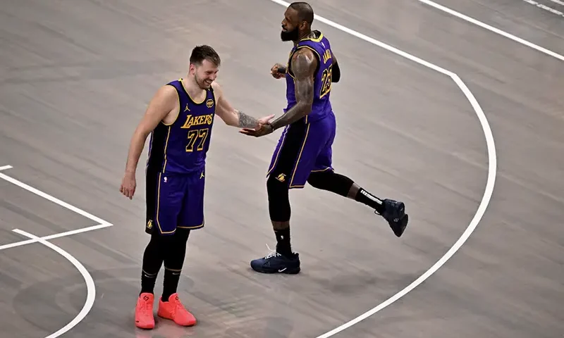 Los Angeles Lakers guard Luka Doncic (77) and Lakers forward LeBron James (23) celebrate during the fourth quarter against the Dallas Mavericks at the American Airlines Center. Mandatory Credit: Jerome Miron-Imagn Images