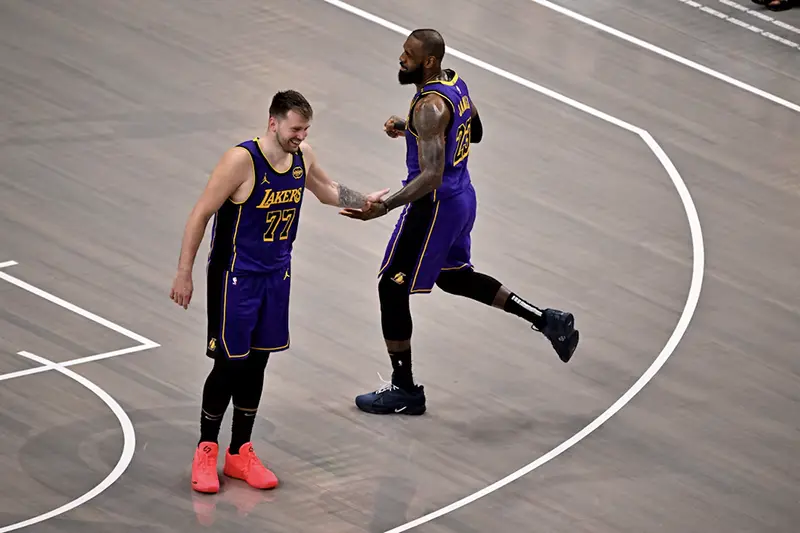 Los Angeles Lakers guard Luka Doncic (77) and Lakers forward LeBron James (23) celebrate during the fourth quarter against the Dallas Mavericks at the American Airlines Center. Mandatory Credit: Jerome Miron-Imagn Images