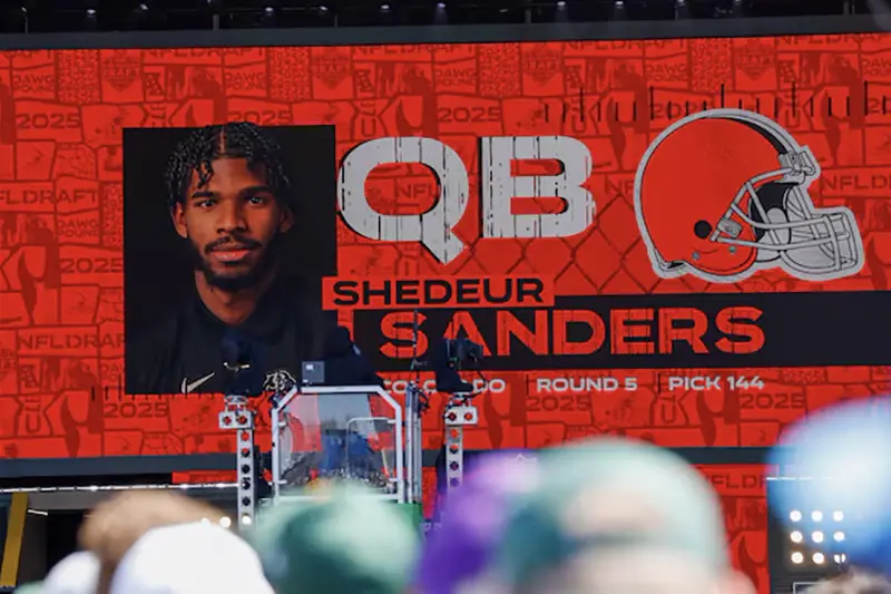 A graphic announcing Colorado quarterback Shedeur Sanders’ selection by the Cleveland Browns with the 144th overall pick is seen in the Draft Theater during the third day of the 2025 NFL Draft at Lambeau Field. Mandatory Credit: Tork Mason/USA Today Network via Imagn Images/File Photo