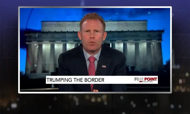 Video still of the host of Fine Point at the desk of their talk show on One America News Network.