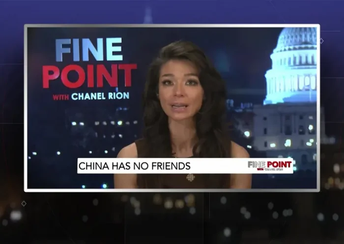 Video still of the host of Fine Point at the desk of their talk show on One America News Network.