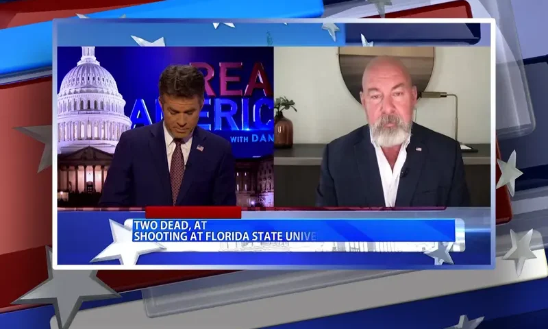 Video still from Real America on One America News Network showing a split screen of the host on the left side, and on the right side is the guest, Jonathan Gilliam.