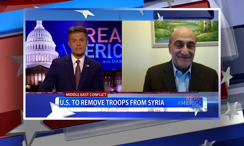 Video still from Real America on One America News Network showing a split screen of the host on the left side, and on the right side is the guest, Dr. Walid Phares.