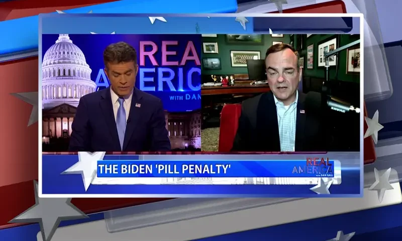 Video still from Real America on One America News Network showing a split screen of the host on the left side, and on the right side is the guest, Tim Murtaugh.