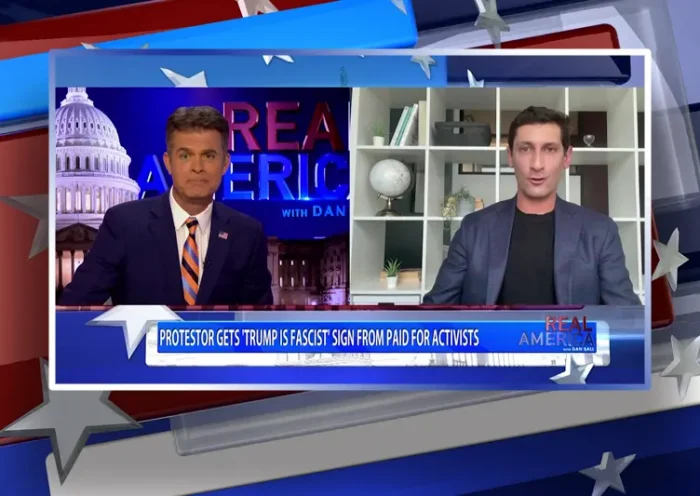 Video still from Real America on One America News Network showing a split screen of the host on the left side, and on the right side is the guest, Adam Swart.