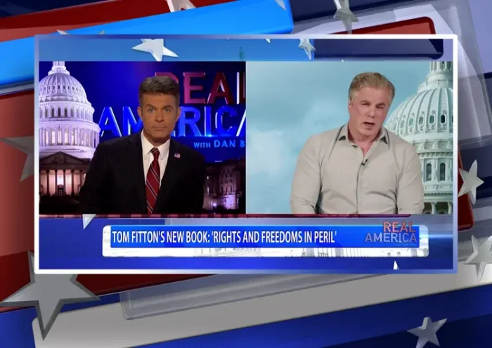 Video still from Real America on One America News Network showing a split screen of the host on the left side, and on the right side is the guest, Tom Fitton.