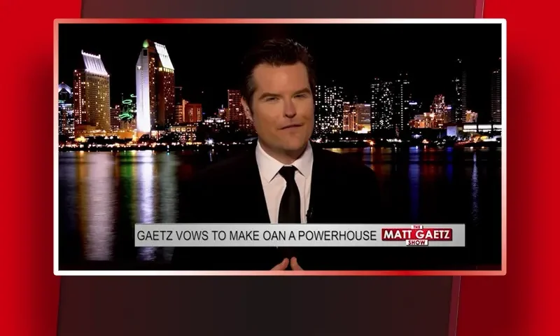Video still of the host of The Matt Gaetz Show at the desk of their talk show on One America News Network.