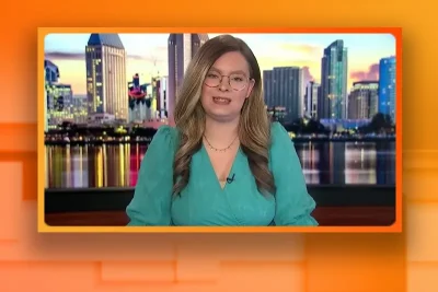 Video still of the host of Tipping Point at the desk of their talk show on One America News Network.